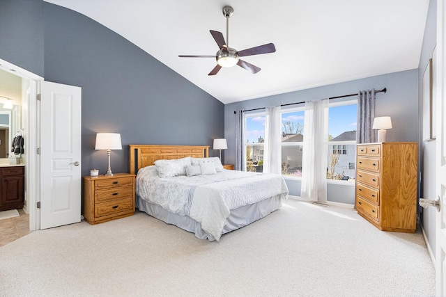 bedroom with a ceiling fan, high vaulted ceiling, ensuite bath, and light carpet