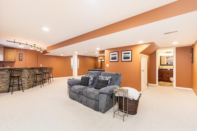 living area featuring baseboards, recessed lighting, wet bar, and light colored carpet
