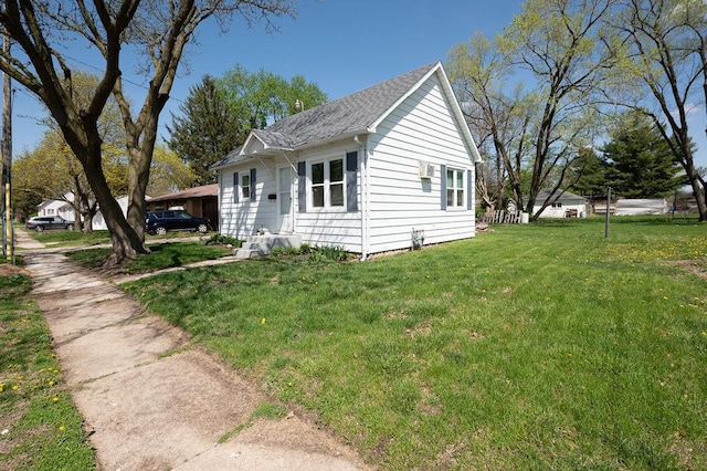 view of home's exterior with a yard and roof with shingles