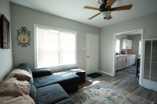 living area featuring ceiling fan, wood finished floors, and baseboards