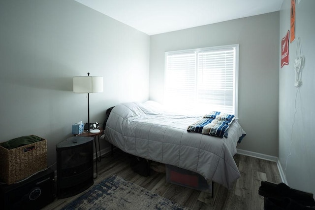 bedroom featuring wood finished floors and baseboards
