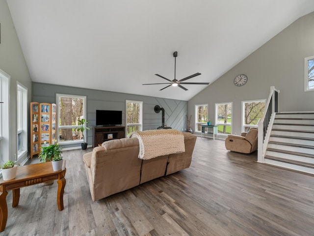 living room with wood finished floors, plenty of natural light, high vaulted ceiling, and a ceiling fan