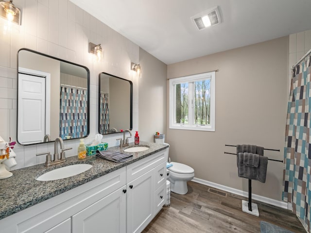 full bathroom featuring wood finished floors, visible vents, and a sink