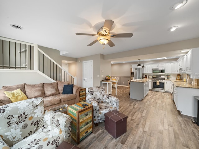 living area featuring recessed lighting, stairway, ceiling fan, light wood-type flooring, and visible vents