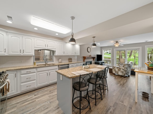 kitchen featuring a breakfast bar area, light wood-type flooring, range, and a sink