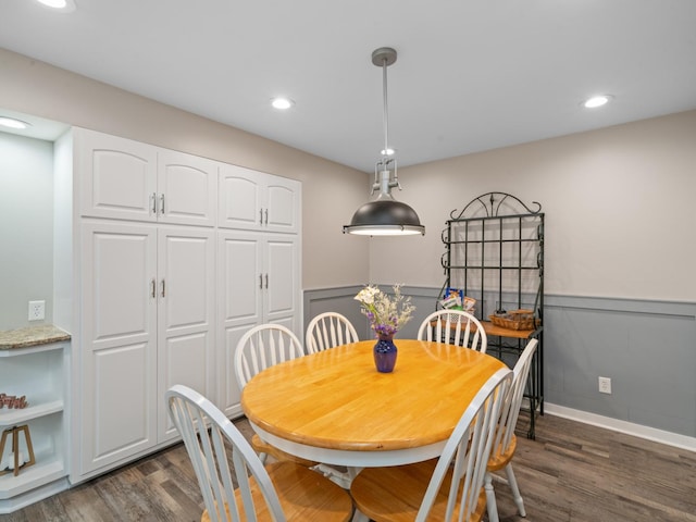 dining room featuring recessed lighting, a wainscoted wall, and dark wood-type flooring