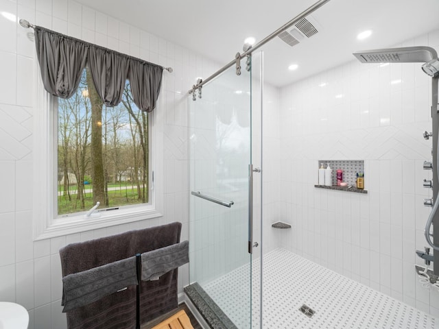 bathroom featuring a stall shower, visible vents, and plenty of natural light