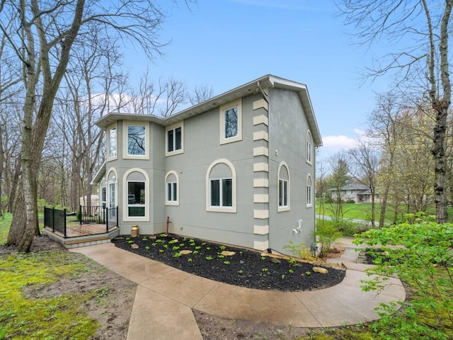 view of front facade featuring a wooden deck and stucco siding