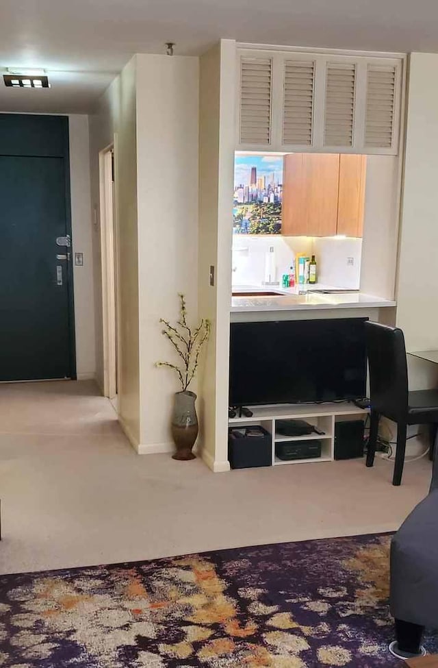 carpeted living area featuring baseboards