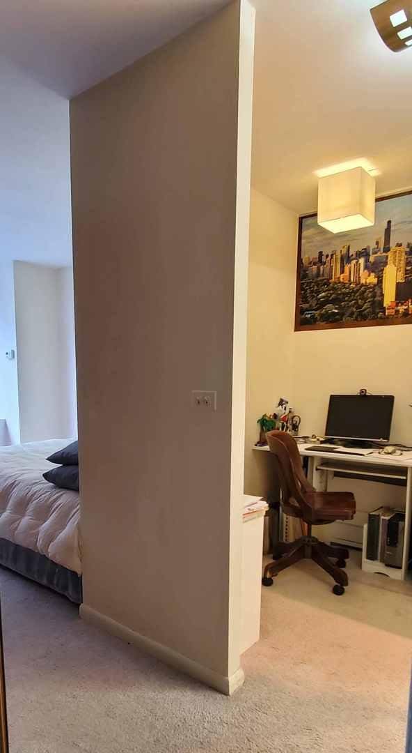 corridor with carpet floors, a desk, and baseboards