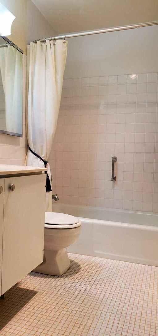 full bathroom featuring shower / tub combo, vanity, toilet, and tile patterned flooring