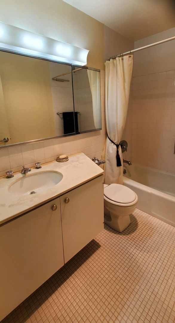 full bath with shower / bath combination with curtain, toilet, vanity, and tile patterned floors