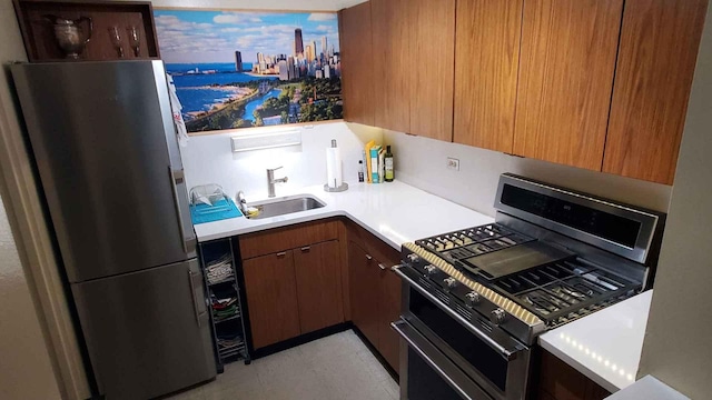 kitchen featuring stainless steel appliances, a sink, and light countertops