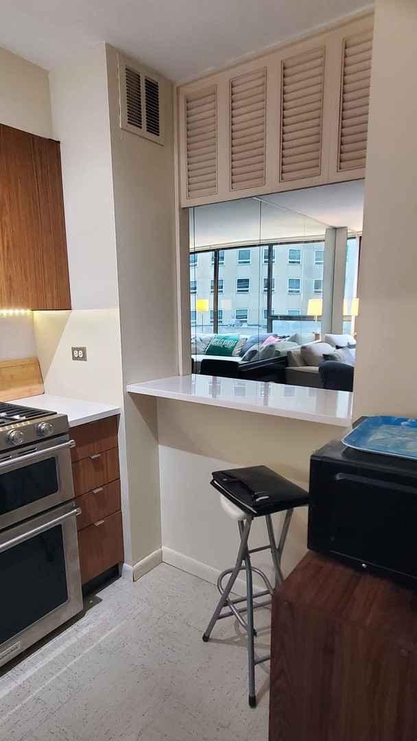 kitchen featuring double oven range, light countertops, and baseboards
