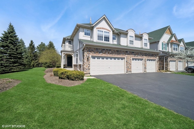 view of front facade with an attached garage, a front lawn, aphalt driveway, stucco siding, and a balcony