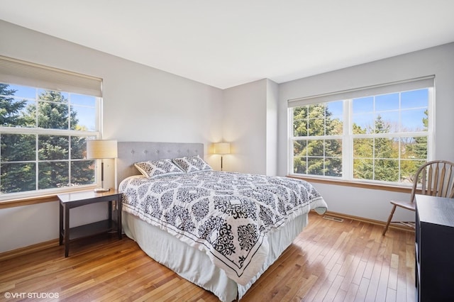 bedroom featuring baseboards, visible vents, and light wood-style flooring