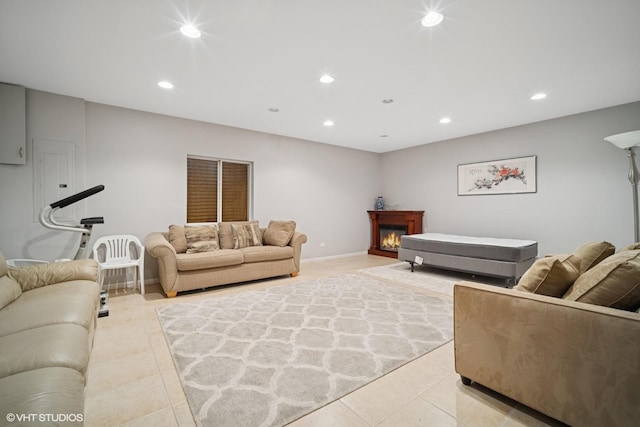 living area with recessed lighting, baseboards, a lit fireplace, and light tile patterned floors