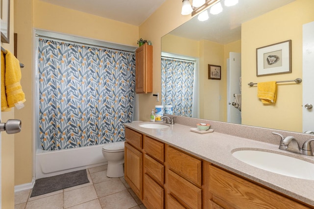 bathroom with a sink, tile patterned floors, toilet, and double vanity