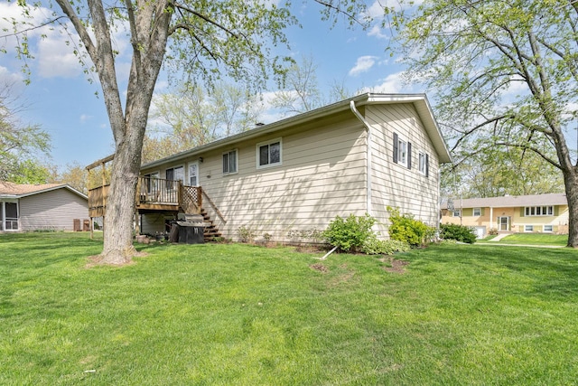 rear view of house featuring stairs, a yard, and a deck