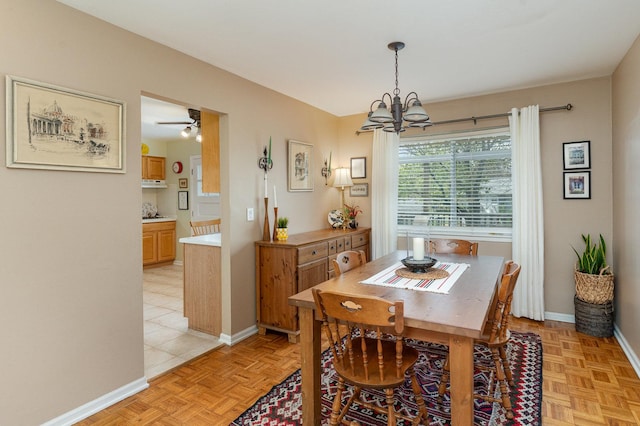 dining space with baseboards and a notable chandelier