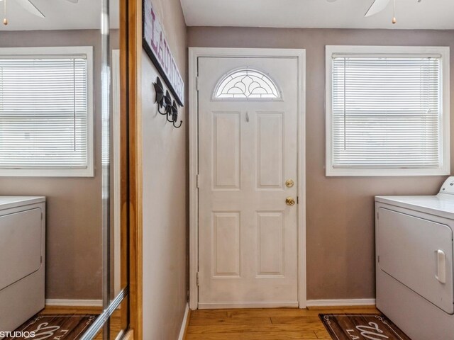 laundry area with ceiling fan, laundry area, washing machine and dryer, baseboards, and light wood-style floors