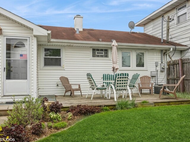 back of property featuring roof with shingles, fence, a yard, and a deck