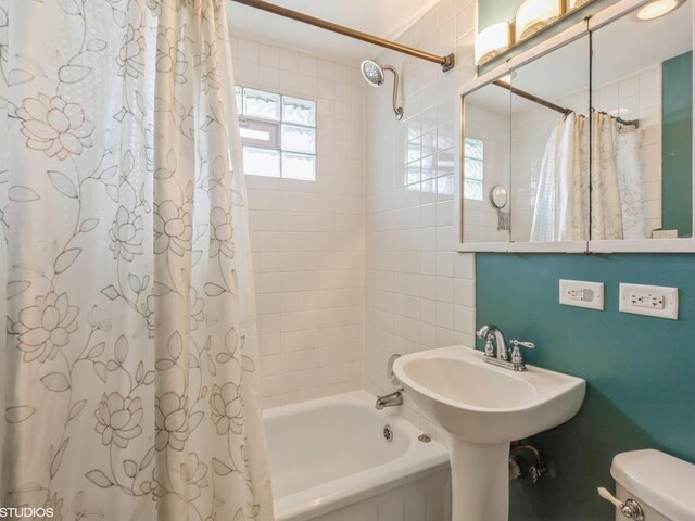 bathroom featuring toilet and shower / tub combo with curtain
