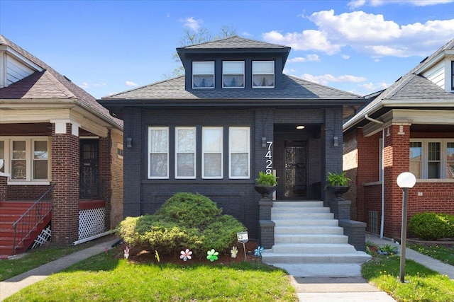 bungalow with brick siding and a shingled roof