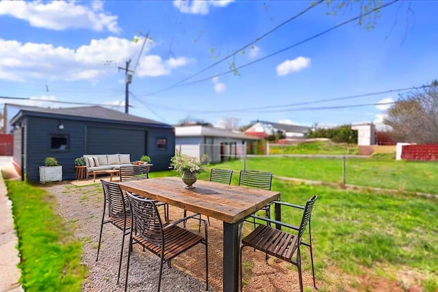 view of patio featuring a detached garage, an outdoor living space, fence, and outdoor dining area