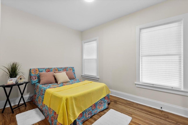 bedroom with wood finished floors and baseboards
