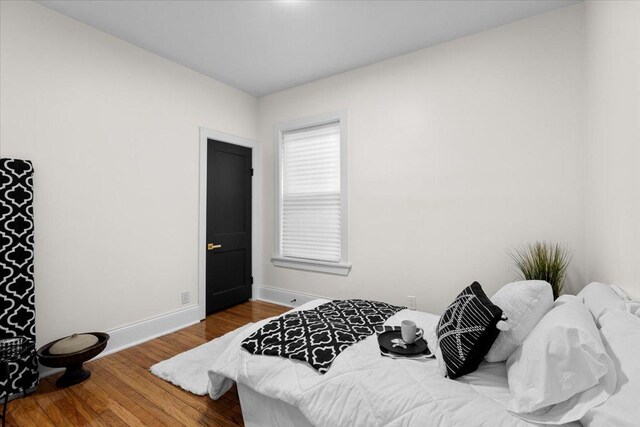 bedroom featuring wood finished floors and baseboards