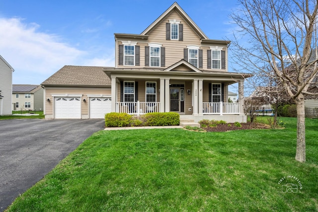 traditional-style house with a garage, a porch, a front lawn, and aphalt driveway