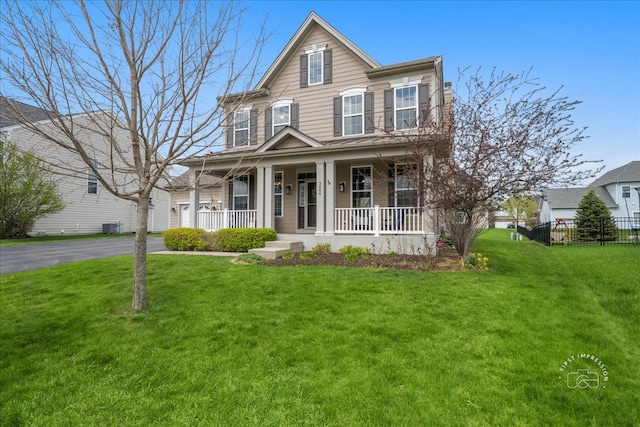traditional home featuring fence, covered porch, and a front yard