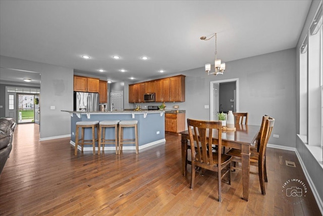 dining room with recessed lighting, baseboards, dark wood-style floors, and an inviting chandelier