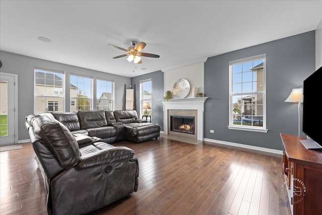 living room with baseboards, ceiling fan, a fireplace, and hardwood / wood-style floors