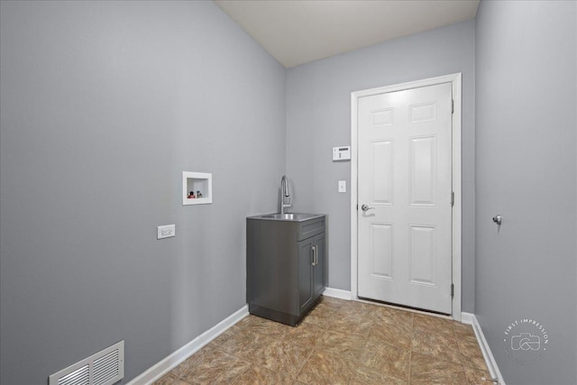 laundry room with visible vents, baseboards, hookup for a washing machine, a sink, and cabinet space