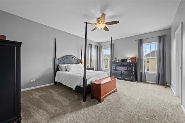 bedroom featuring baseboards, multiple windows, a ceiling fan, and carpet flooring
