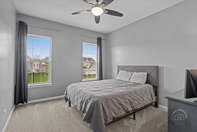 carpeted bedroom with baseboards and a ceiling fan