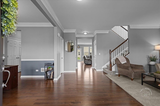foyer featuring baseboards, ornamental molding, wood finished floors, and stairway