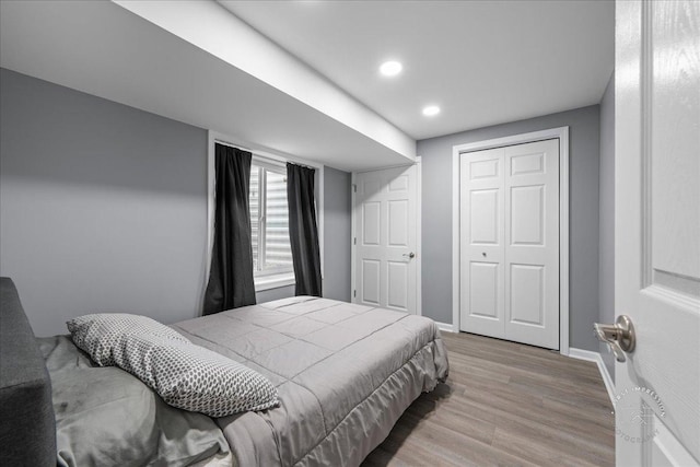 bedroom featuring baseboards, a closet, recessed lighting, and wood finished floors