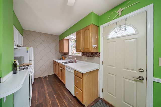 kitchen with white appliances, a sink, light countertops, dark wood finished floors, and tile walls