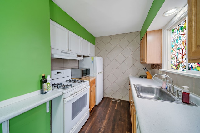 kitchen with white range with gas stovetop, under cabinet range hood, a sink, stainless steel microwave, and light countertops
