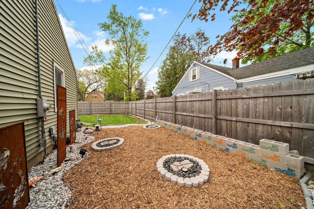 fenced backyard featuring an outdoor fire pit