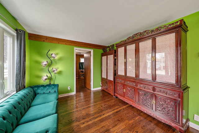 living area featuring plenty of natural light, dark wood-style flooring, baseboards, and vaulted ceiling