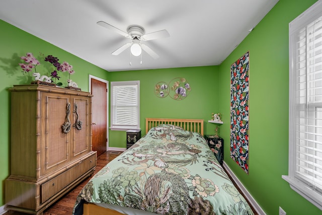 bedroom with multiple windows, baseboards, and dark wood finished floors