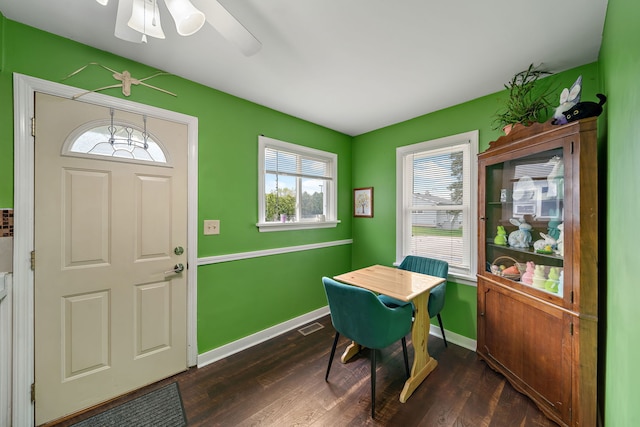 dining area with healthy amount of natural light, dark wood-style flooring, and baseboards