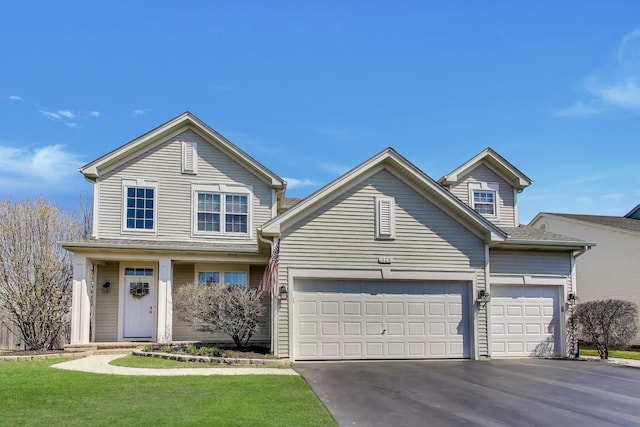 traditional-style home featuring a front lawn, driveway, and a garage