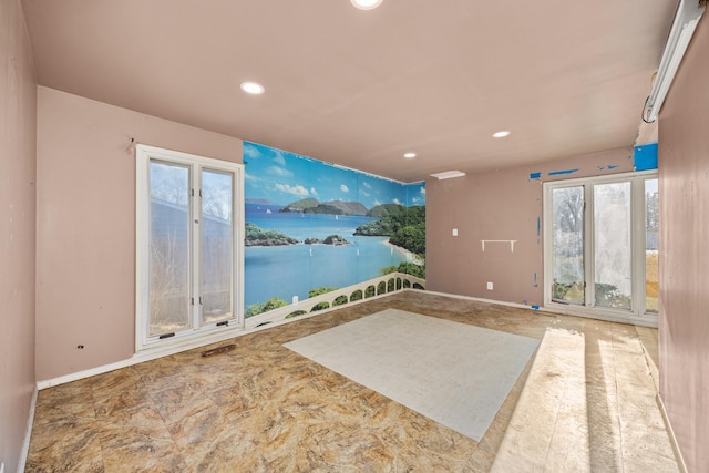 interior space featuring recessed lighting, a healthy amount of sunlight, and a water view