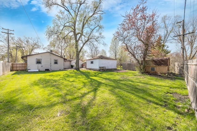 view of yard featuring a fenced backyard, a shed, and an outdoor structure