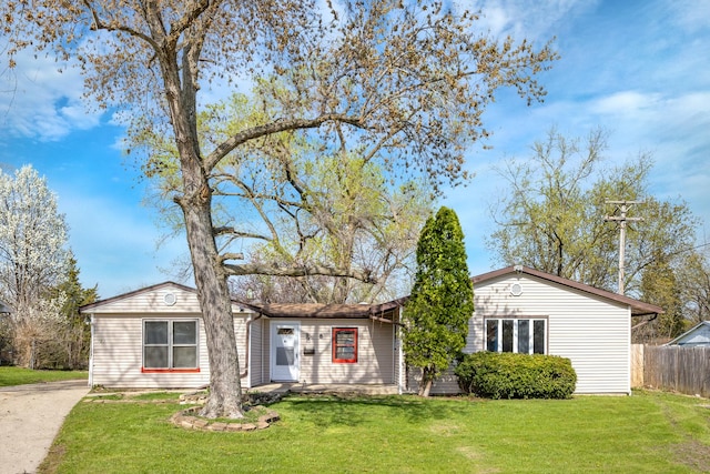 ranch-style house with fence and a front lawn